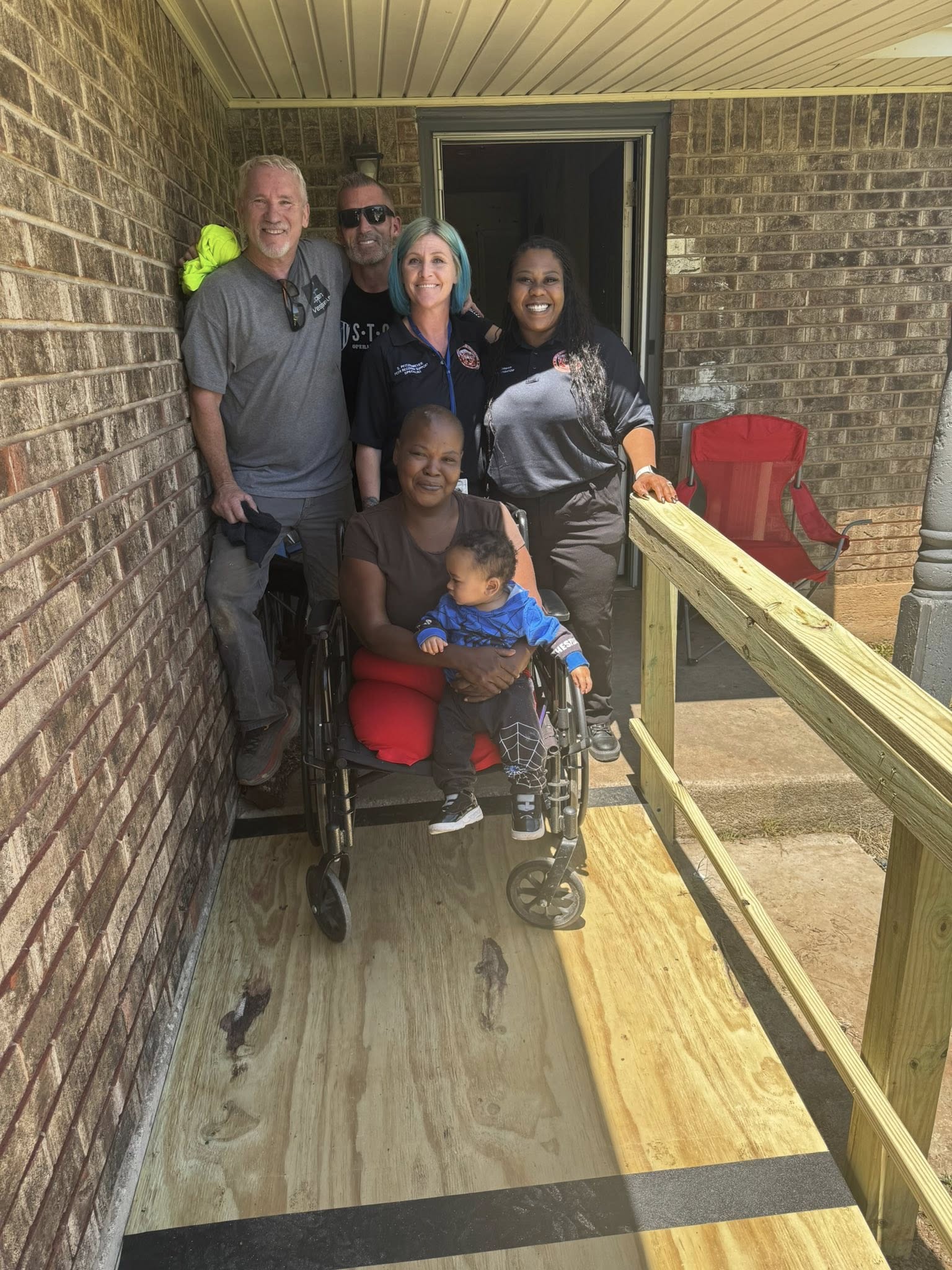 Volunteer team gathered around completed wheelchair ramp